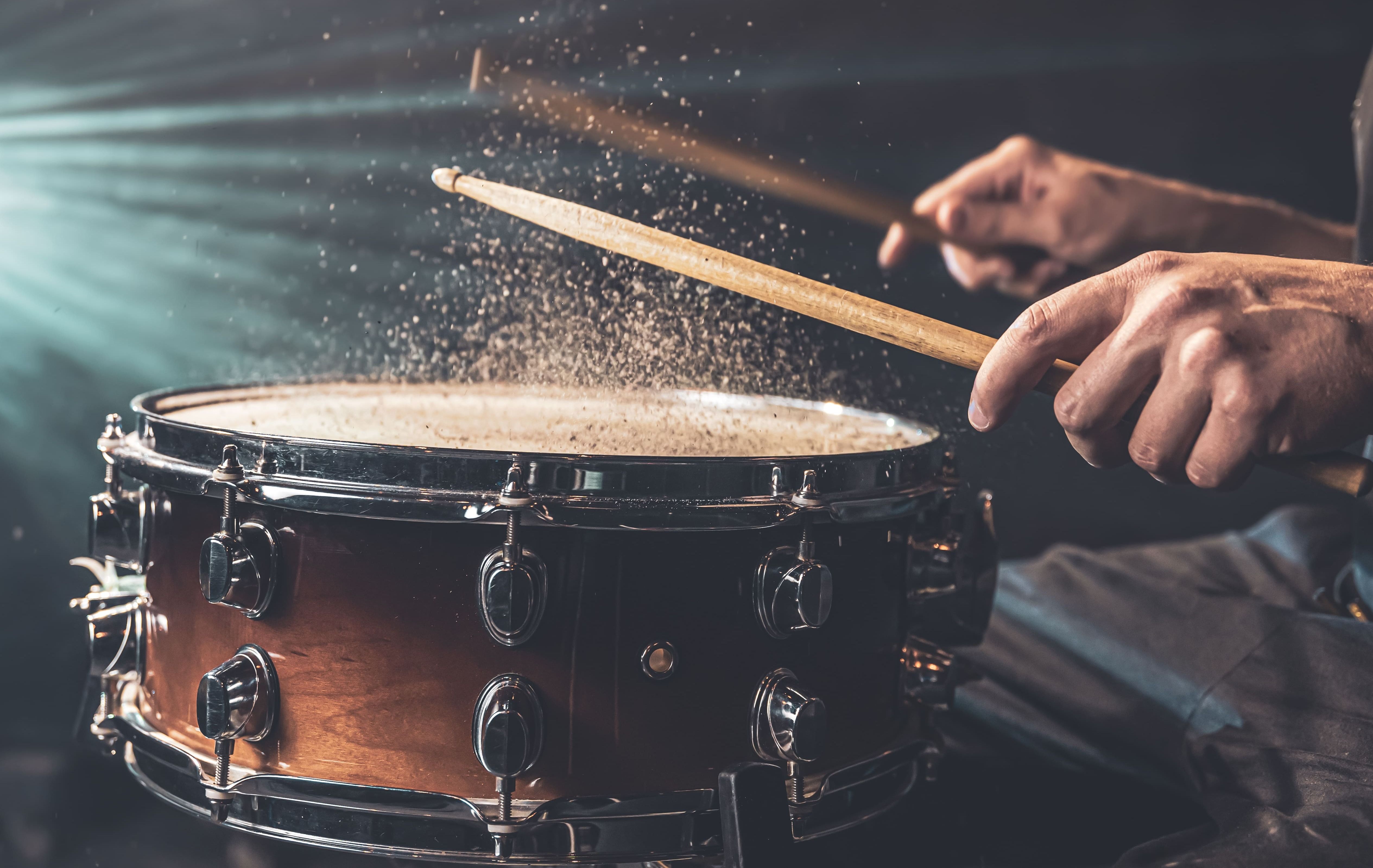 drummer-using-drum-sticks-hitting-snare-drum-with-splashing-water-black-background-studio-lighting-close-up (1) (1).jpg